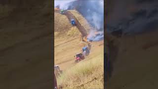 FARMERS PUTTING IN A FIRE BREAK TO STOP GRASS FIRE WITH TRACTORS [upl. by Meer776]