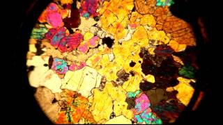 A thin section viewed through a petrographic microscope with stage rotation [upl. by Leahcimed]