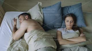 Top view of upset lying sleepless couple in bed offended because of quarrel [upl. by Akimik]