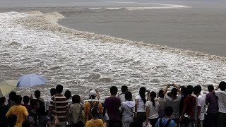 Chinas tidal bore on the Qiantang river draws eager spectators [upl. by Eiuol]